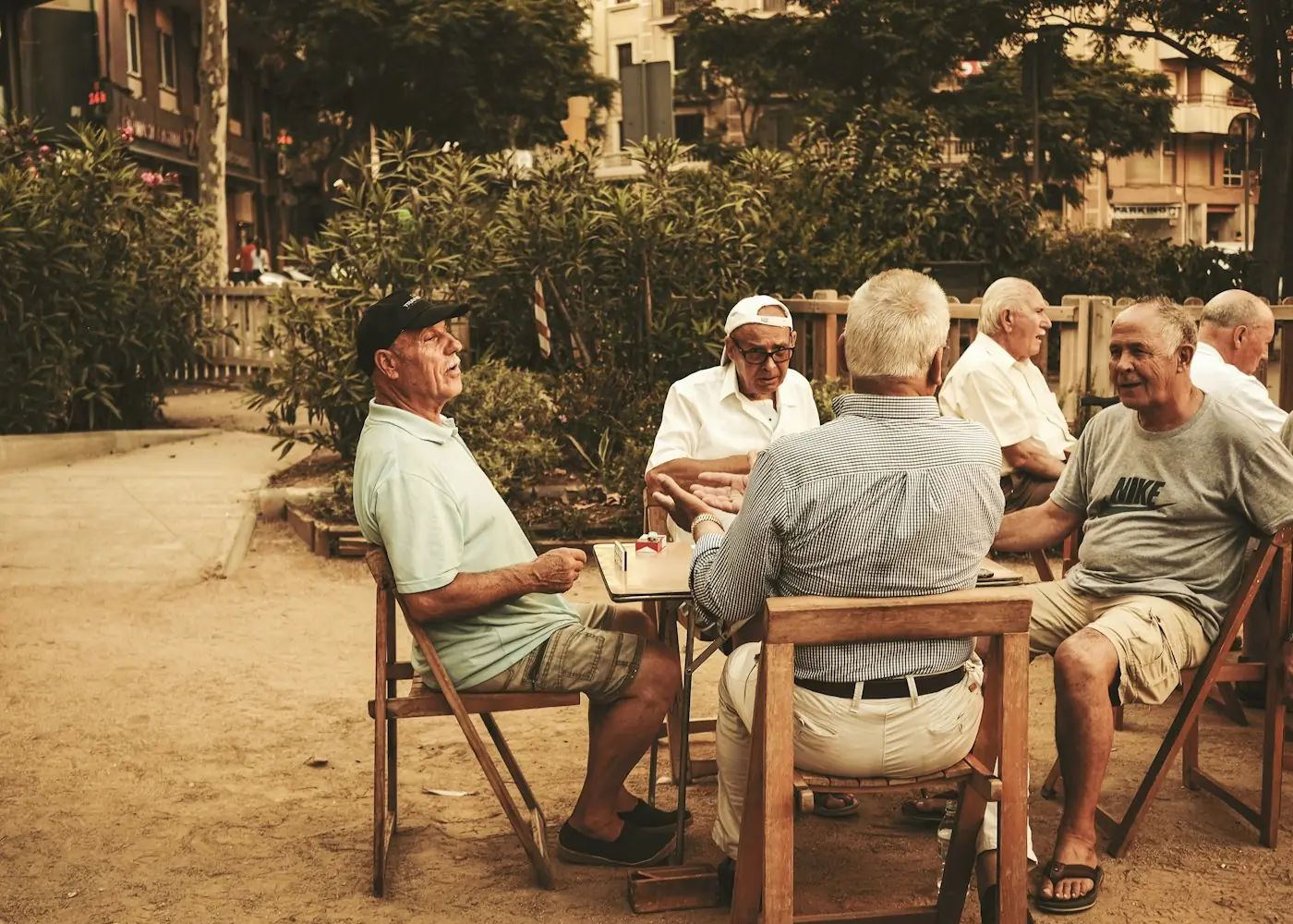 Ältere Männer sitzen gemeinsam an einem Tisch im Freien
